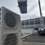 crane-lifting-hvac-condenser-onto-rooftop-of-commercial-building crane lifting hvac condenser onto rooftop of commercial building